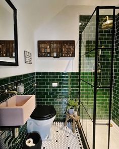 a black and white tiled bathroom with green tiles