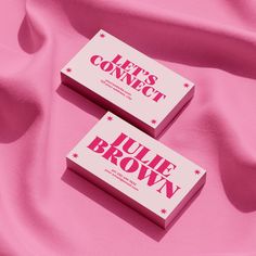 two pink business cards sitting on top of a pink cloth covered in stars and the words let's connect