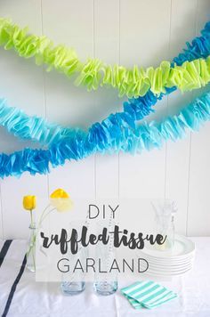 colorful streamers are hanging from the ceiling above a table with plates and cups on it