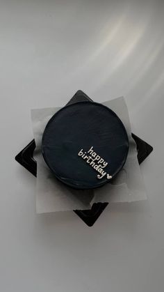 a birthday cake sitting on top of a piece of paper with the words happy birthday written on it