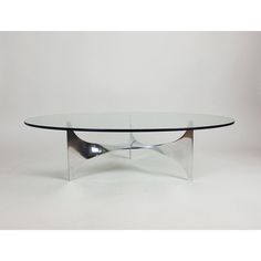 a glass and chrome coffee table with curves on the top, against a white background