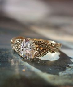 a close up of a ring with a diamond in the center on a piece of cloth