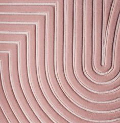 a pink rug with white lines on the bottom and sides, in an abstract pattern