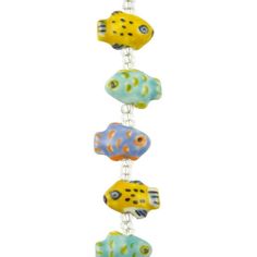 a multi colored glass bead hanging from a metal hook on a white background with an orange, yellow and blue fish design