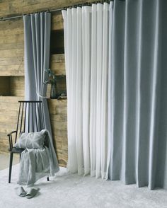 a chair sitting next to a window covered in curtains