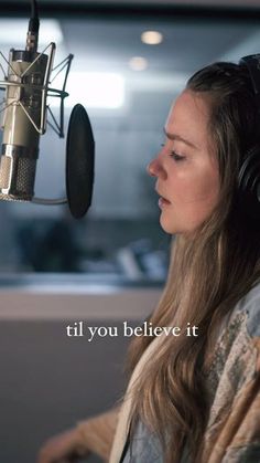 a woman with headphones on sitting in front of a microphone