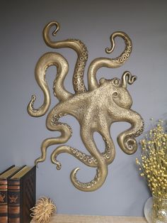 an octopus sculpture on the wall next to some books