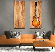 two guitars are hanging on the wall in this living room with orange couches and pillows