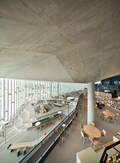 an empty library filled with lots of tables and chairs next to bookshelves full of books