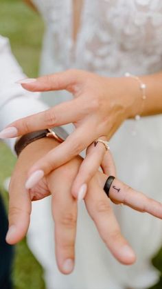 two people holding hands with rings on their fingers