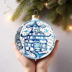 a hand holding a blue and white ornament