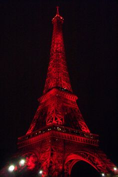 the eiffel tower lit up in red at night