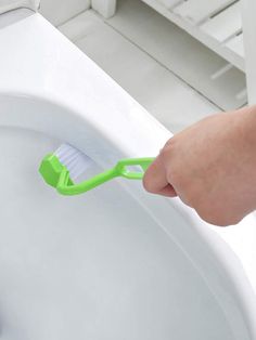 a person brushing their teeth with a toothbrush in front of a white toilet bowl