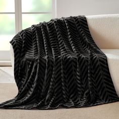 a black and white blanket sitting on top of a couch