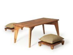 a wooden table and bench with two pillows on the bottom one is made out of wood