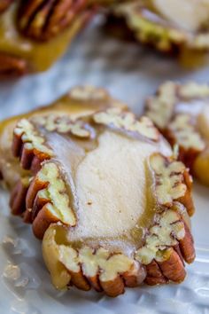 some kind of food on a plate with nuts and other things in the back ground