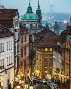 a city street filled with lots of traffic next to tall buildings and green dome tops