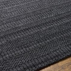 a black rug on top of a wooden floor