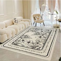 a living room with white couches and a large rug on the floor in front of a window