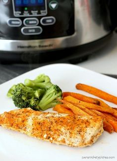 there is a piece of fish and some carrots on the plate next to an instant pressure cooker