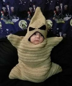 a baby wrapped in a crochet costume