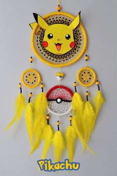 a pokemon themed dream catcher with pikachu on the front and yellow feathers around it