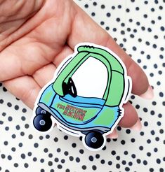 a hand holding a sticker with a car on it