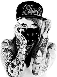 a woman with tattoos and a hat covering her face