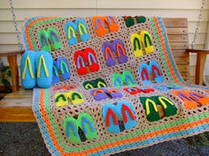 a crocheted blanket with flip flops on it sitting on a porch swing