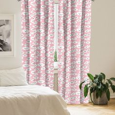 a bed room with a neatly made bed and pink curtains