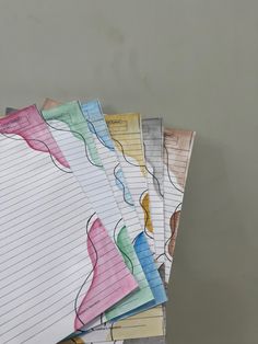 five lined notebooks are stacked on top of each other in different colors and shapes