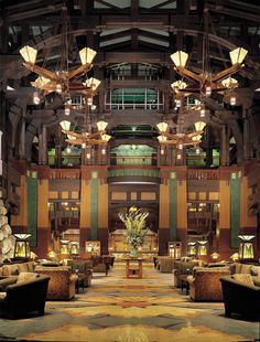 the lobby of a hotel with chandeliers hanging from the ceiling