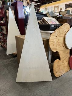 three wooden christmas trees sitting next to each other in a room with bookshelves