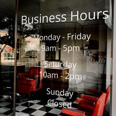 an advertisement for business hours is displayed in a window with black and white checkered flooring