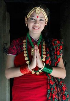 a woman in red and green dress holding her hands together