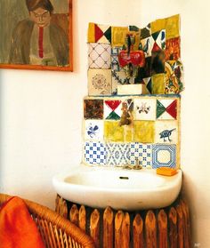 a white sink sitting next to a wooden radiator under a painting on the wall