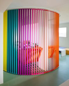 the colorful room is decorated with white walls and furniture, along with multicolored partitions