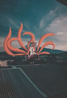 a woman standing on top of a roof next to a large orange dragon sculpture in the sky