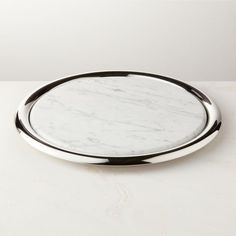 an oval marble tray with black rim on a white countertop, viewed from the front