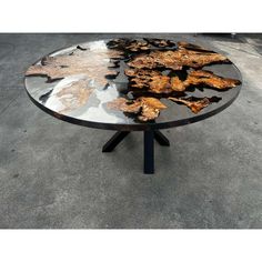 a round table with black and gold leaves on it