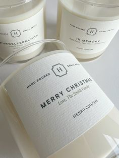 three candles with labels on them sitting next to each other