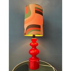 a red lamp sitting on top of a glass table