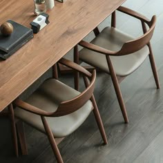 a wooden table with chairs around it and a book on the top of one chair