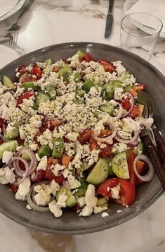 a salad with tomatoes, cucumbers, onions and feta cheese in a bowl