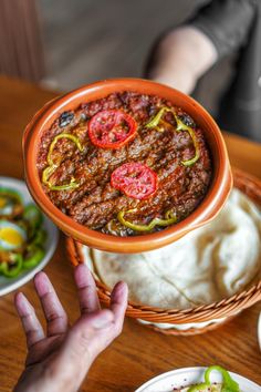 a person is reaching for food in a bowl