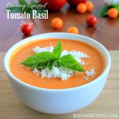 a white bowl filled with tomato soup and garnished with parmesan cheese