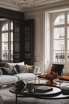 a living room filled with furniture and large windows