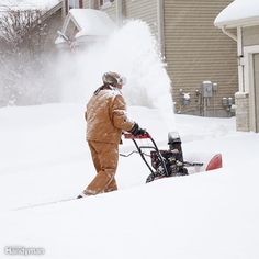 a man is using a snow blower to clear the snow off his driveway and lawn