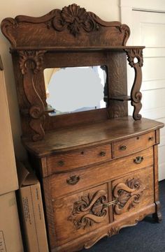 an old wooden dresser with a mirror on top