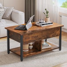 a wooden coffee table with a laptop on top and some books in front of it